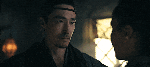 a man and a woman look at each other in a dark room