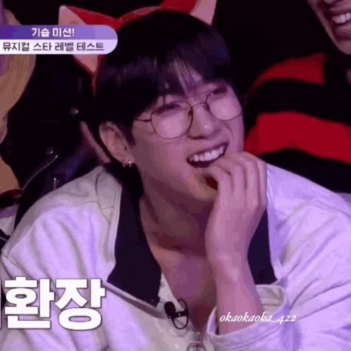 a young man wearing glasses and a cat ear headband with korean writing on it