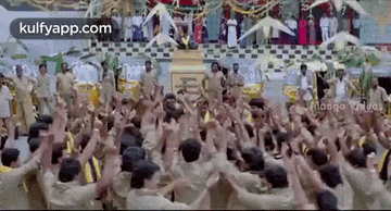 a large group of people are standing in a circle with their hands up in the air .