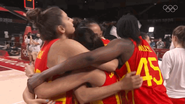 a group of female basketball players are hugging each other and one of them has the number 45 on her back