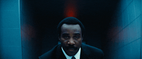 a dark hallway with a red light on the wall above the door
