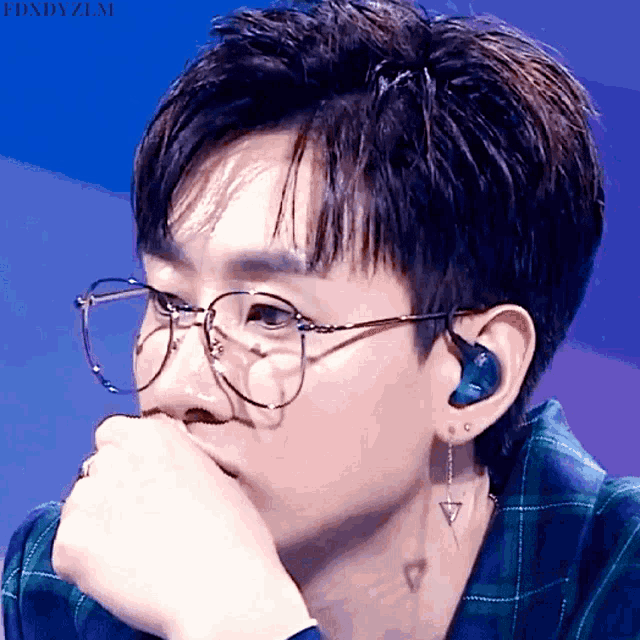 a close up of a person wearing glasses and ear buds with the words fdxdyzlm above