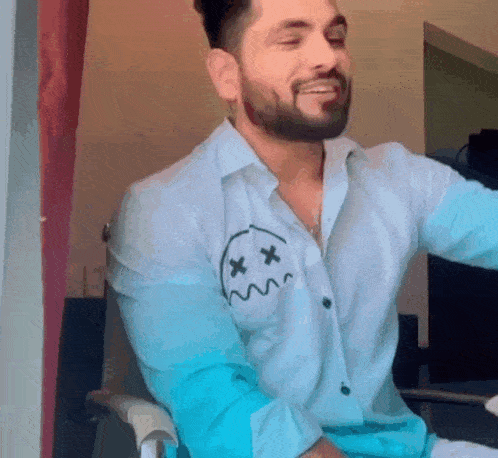 a man with a beard is wearing a shirt with a smiley face on it