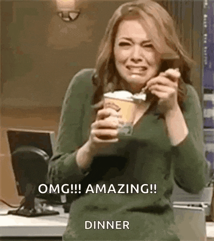 a woman is holding a cup of ice cream and a spoon .