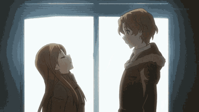 a man and a woman are standing next to each other in front of a window with tokyo mx on the bottom right