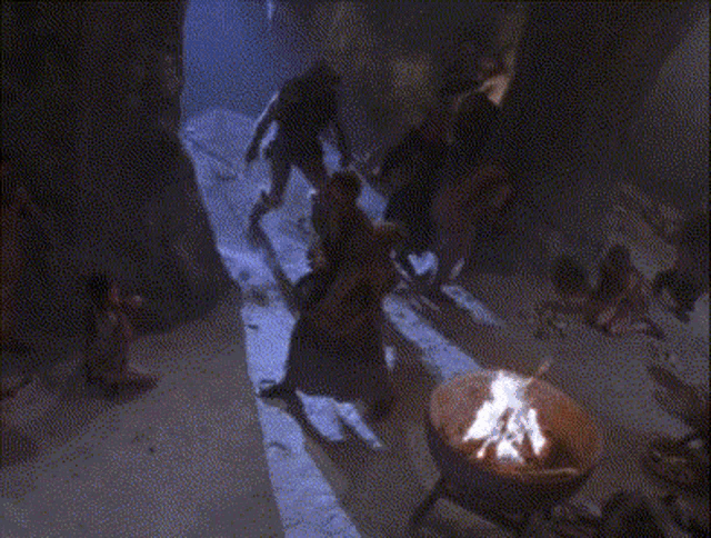 a group of people standing around a fire with the words work written on the bottom