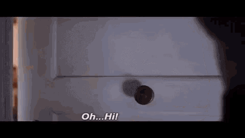 a person is standing in front of a door and talking to another person .