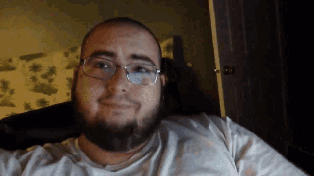 a man with a beard and glasses is smiling