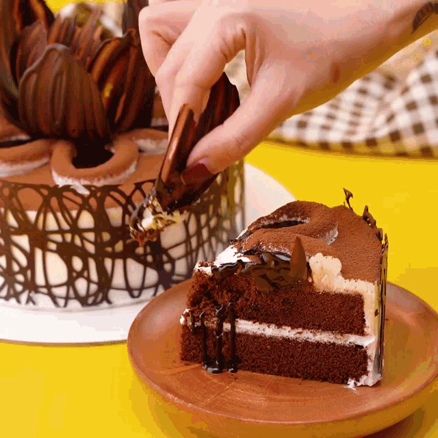 a person is taking a slice of chocolate cake from a plate