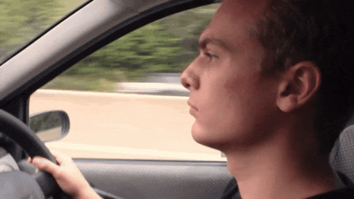 a man is driving a car with his head turned to the side