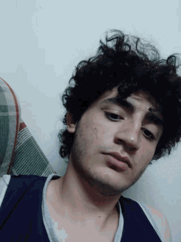 a man with curly hair and a beard laying on his back