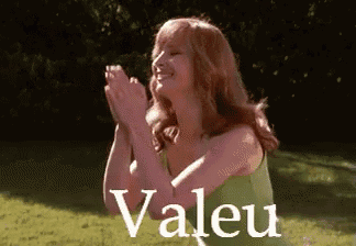 a woman in a green dress is clapping her hands with the word valeu in the background