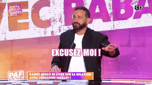 a man with a beard stands in front of a sign that says " excusez-moi "