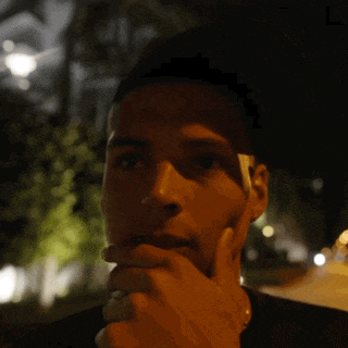 a man talking on a cell phone at night with his hand on his face