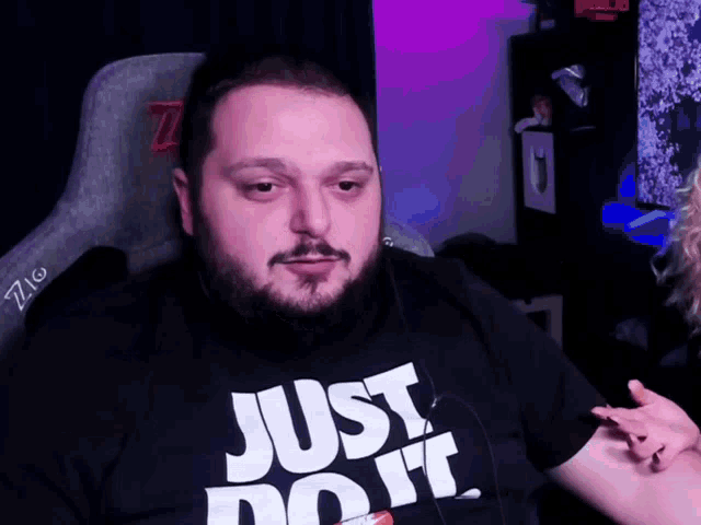 a man with a beard wearing a just do it shirt