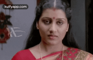 a woman in a red sari is making a funny face .