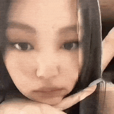 a close up of a woman 's face with a hand on her face .