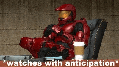 a red spartan is sitting on a chair with a cup of coffee .