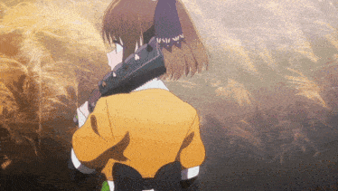 a girl in a yellow jacket is holding a large saw