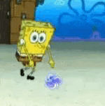 spongebob squarepants is playing soccer with a purple ball in the sand .