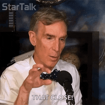 a man in a bow tie is sitting in front of a microphone and holding a toy .