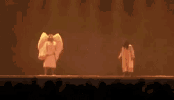 a blurred image of two people on a stage with the word adeus on the bottom right