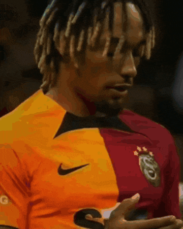 a man wearing a yellow and red jersey with the number 2 on the sleeve