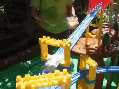 a person is playing with a toy train set outside .