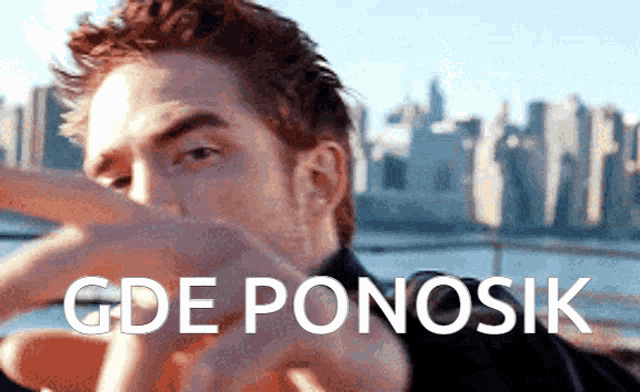 a man is pointing at the camera with the words gde ponosik written above him