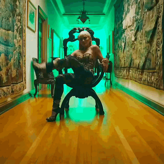 a woman sits in a chair in a hallway with green lights