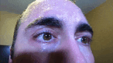 a close up of a man 's face with sweat coming out of his forehead