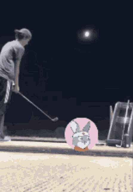 a man is swinging a golf club on a golf course with a picture of a rabbit on the ground