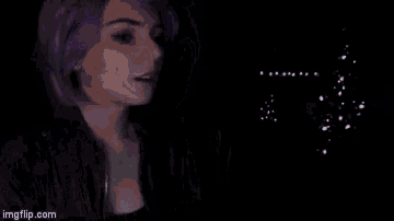 a blurry picture of a person 's face in a dark room with bubbles coming out of it .