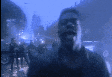a man stands in front of a crowd of people in a blurry photo