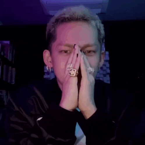 a man with a ring on his finger is praying with his hands folded .
