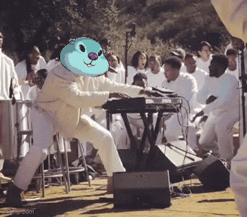 a man wearing a blue hamster mask is playing a keyboard in front of a crowd of people
