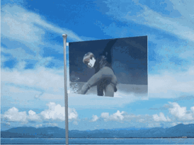 a flag with a picture of a person on it is flying in the wind