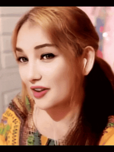 a woman with red hair is wearing a yellow jacket