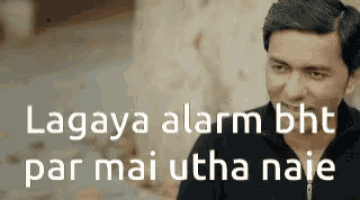 a man is sitting in front of a sign that says lagaya alarm bht par mai utha naie