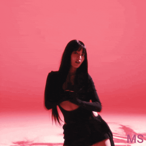 a woman in a black dress is standing in front of a red background that says ms on it