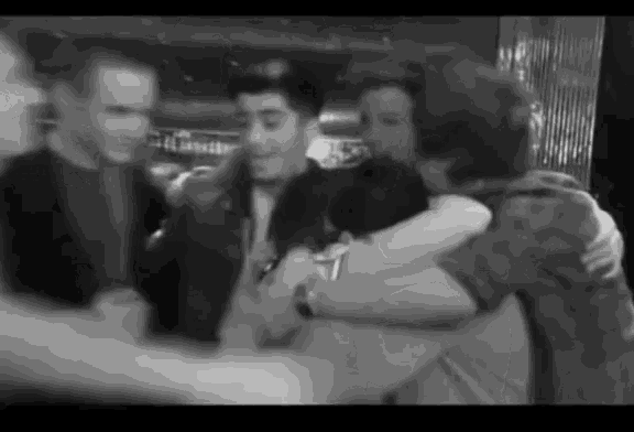 a group of people are hugging in a black and white photo