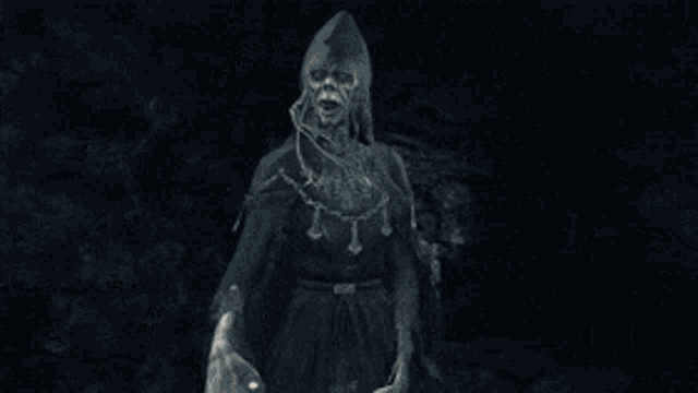 a statue of a skeleton holding a sword in a dark room