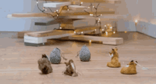 a wooden christmas tree with a bunch of ornaments on the floor