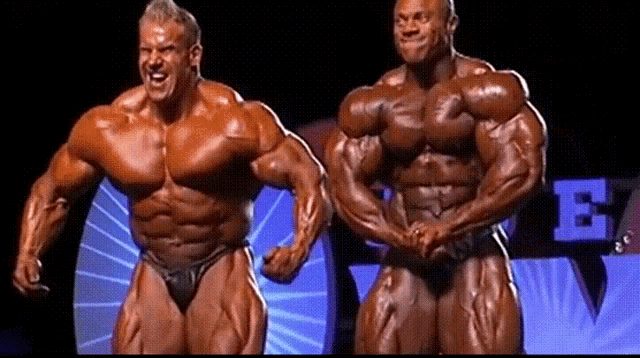 two bodybuilders standing next to each other in front of a sign that has the letter e on it