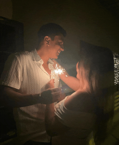 a man and woman holding sparklers in their hands