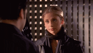 a man and a woman are standing next to each other in a dark room .