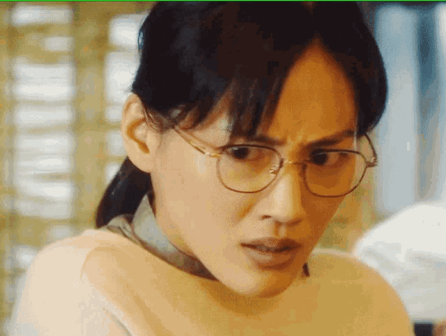 a close up of a woman wearing glasses making a face