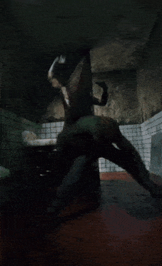 a man in a green shirt is laying on the floor in a dark room