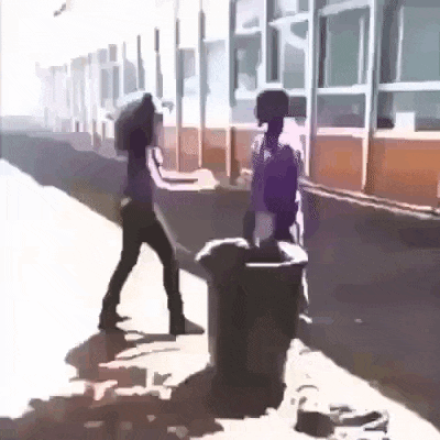 a man and a woman are standing next to each other on a sidewalk next to a trash can .