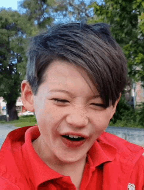 a young boy wearing a red shirt that says ' sydney ' on it